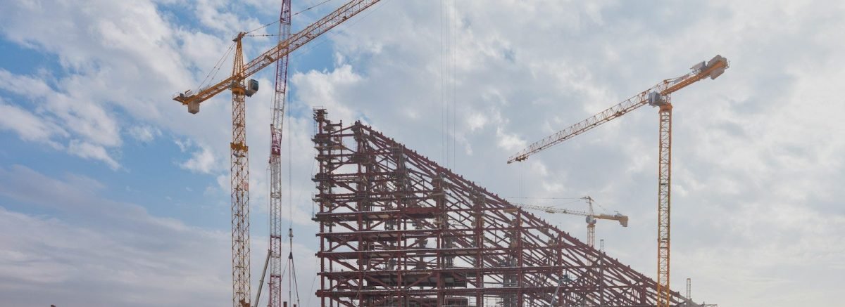 A group of construction cranes sitting on top of a building
